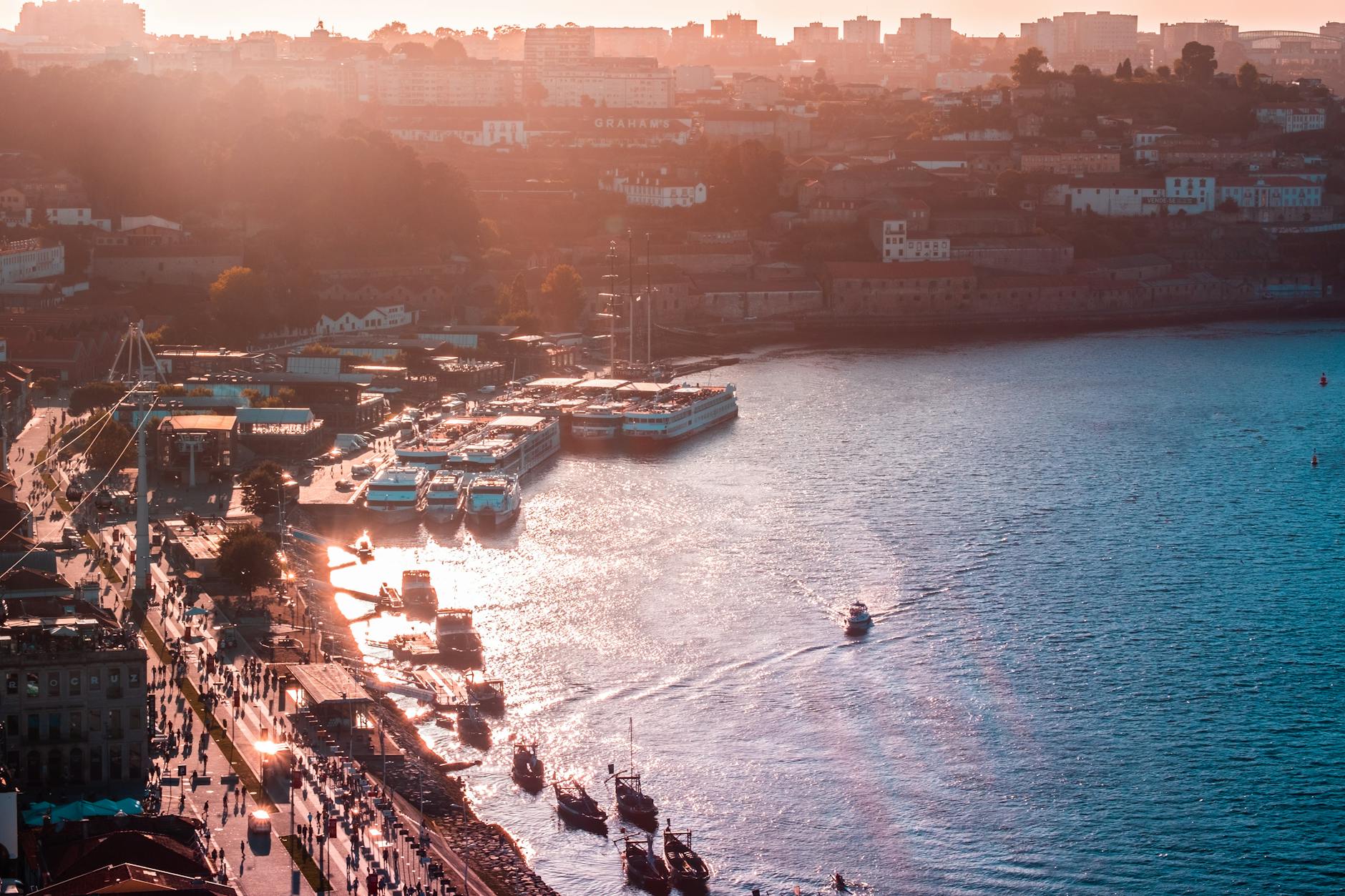 Zachód słońca nad portem w Porto z łodziami i panoramą miasta