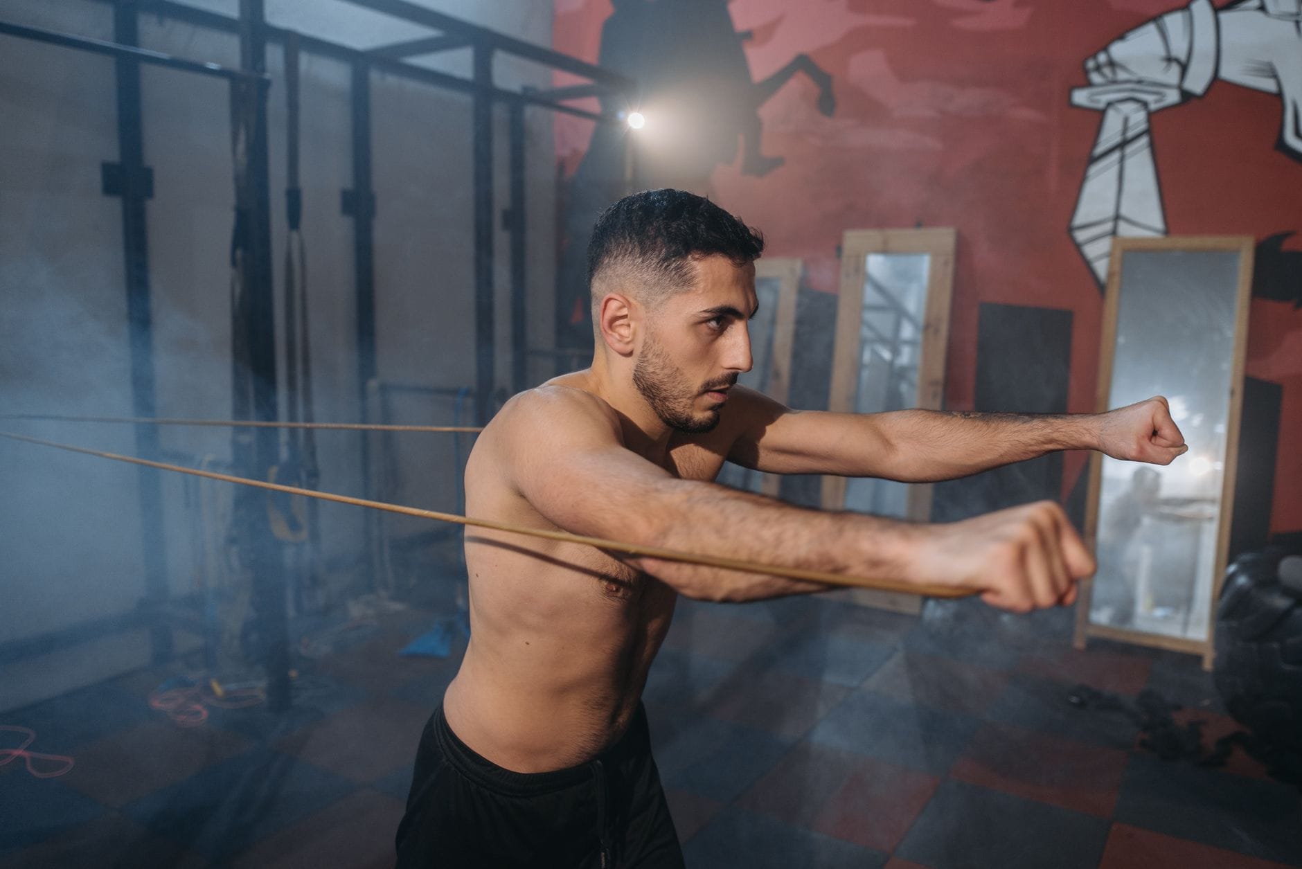 Muskularny mężczyzna ćwiczy z gumami oporowymi na siłowni
