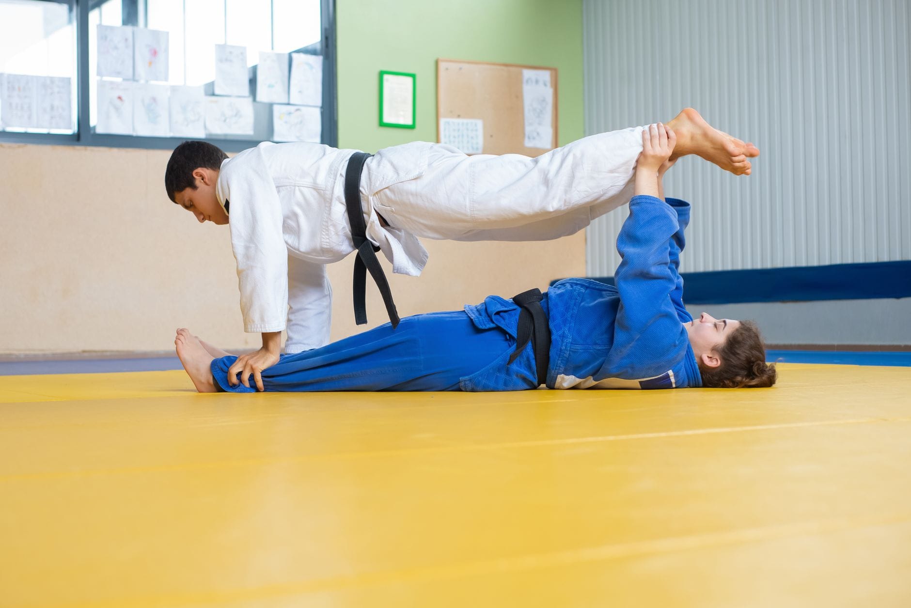 Dwóch judoków ćwiczy techniki rzutów w dojo