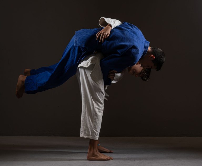 Dwaj judocy walczący boso na macie na czarnym tle